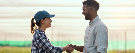 Two people shaking hands on a farm