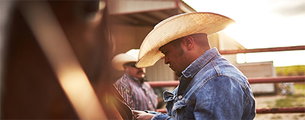 Man with cowboy hat on ranch