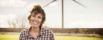 Woman smiling near wind turbine